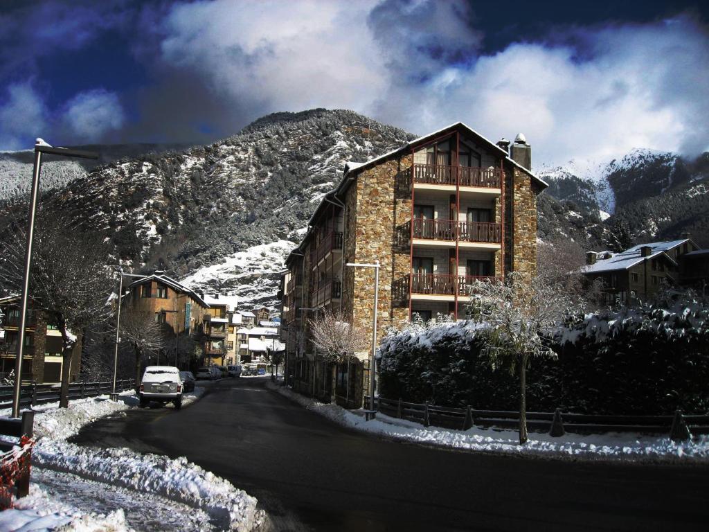 un bâtiment situé sur le côté d'une montagne enneigée dans l'établissement Hotel La Planada, à Ordino