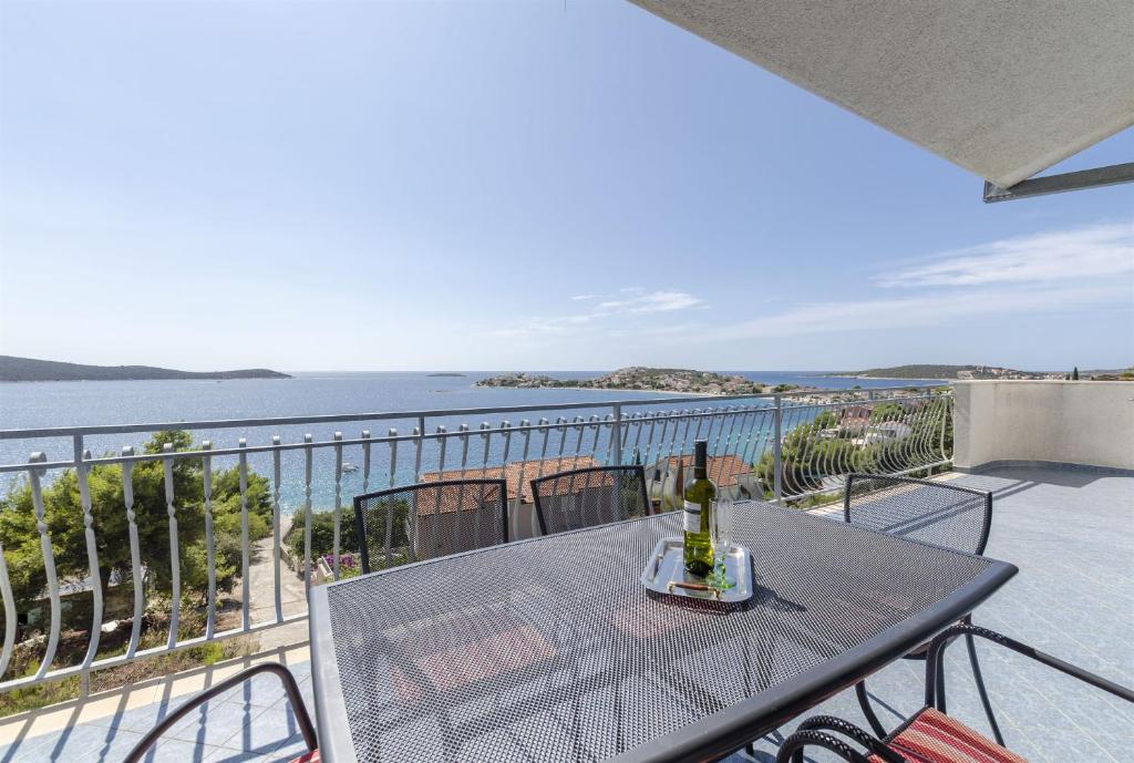 einen Tisch mit einer Flasche Wein auf dem Balkon in der Unterkunft Apartments Ivan in Sevid