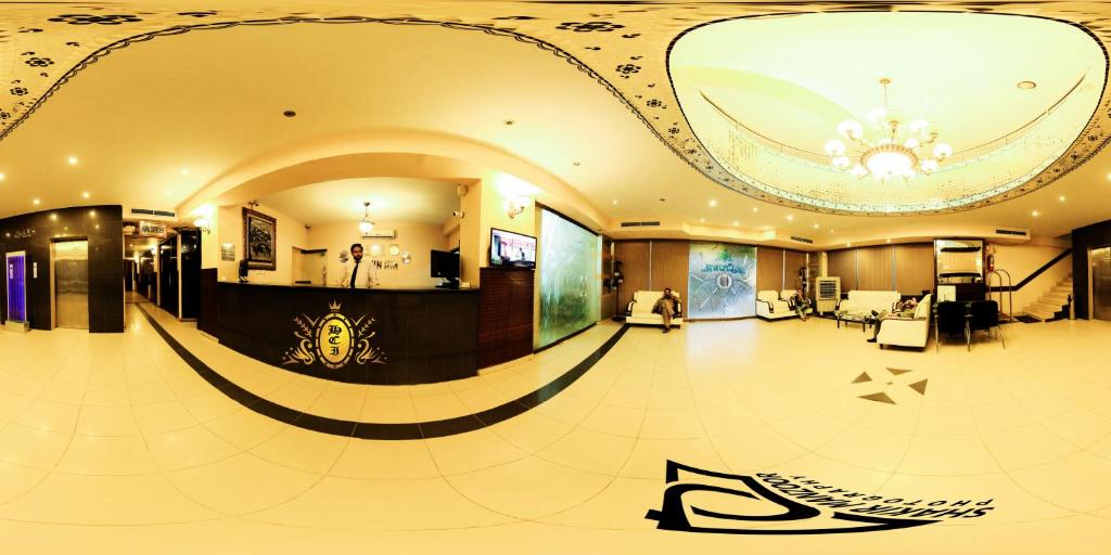 un grand hall avec un lustre au plafond dans l'établissement Hotel Crown Inn, à Karachi