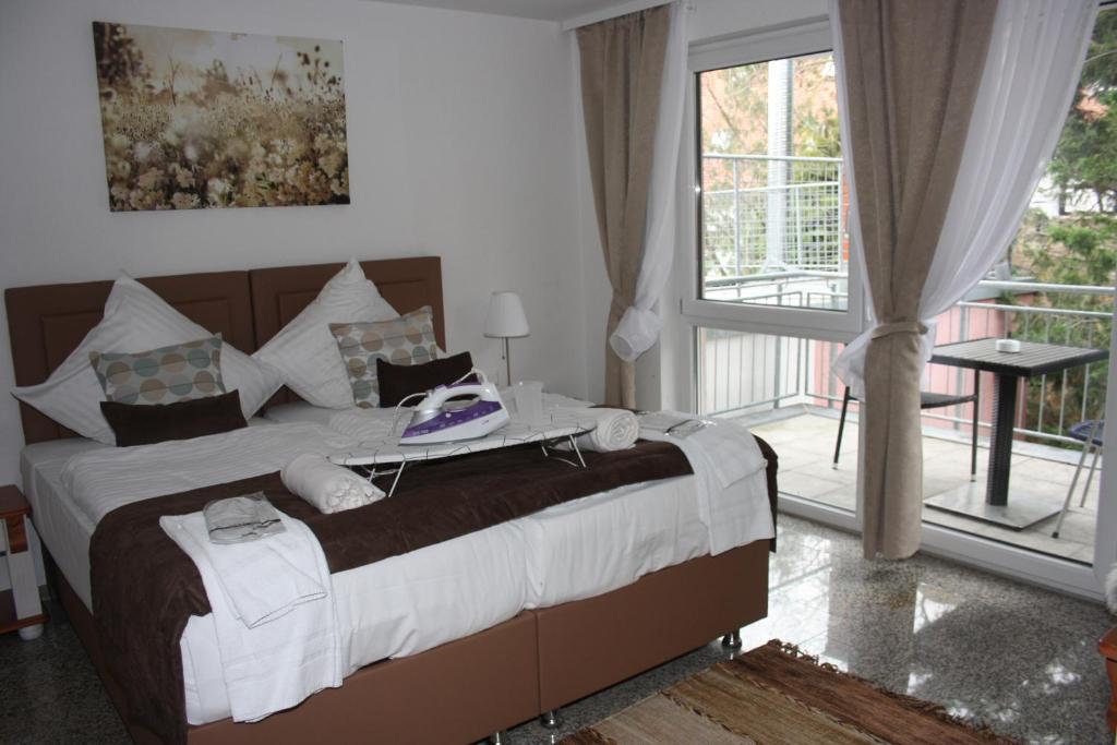 a bedroom with a large bed and a balcony at Hotel Vesa in Sindelfingen
