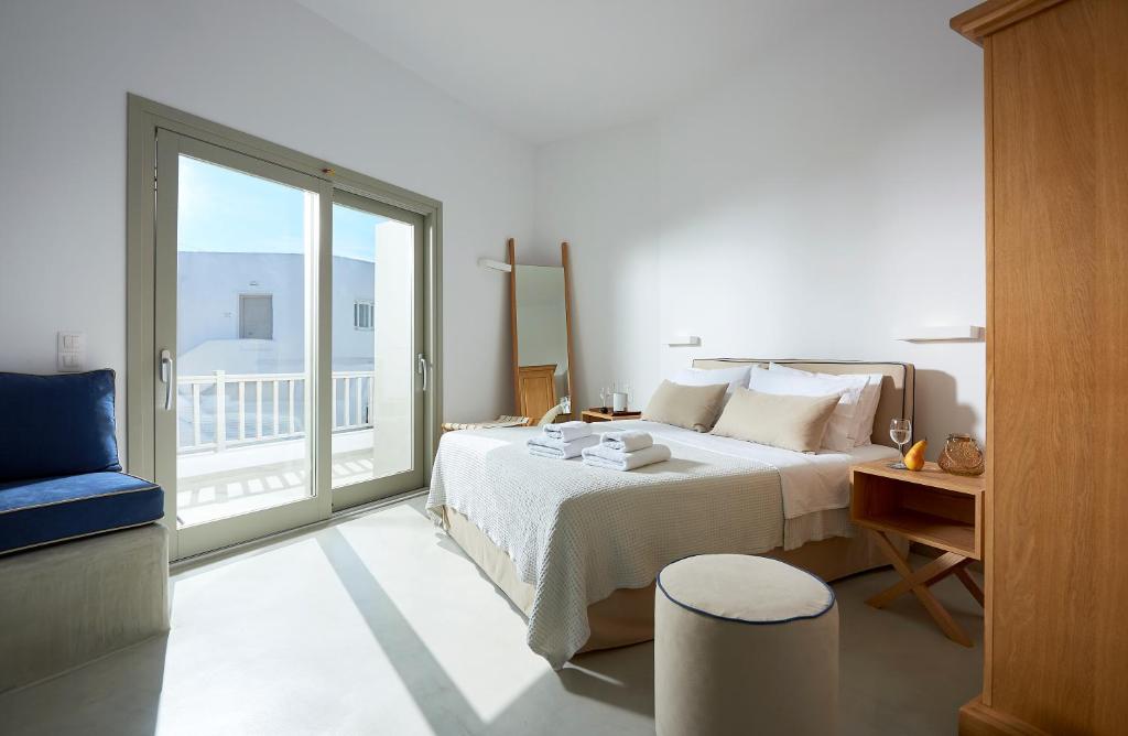 a bedroom with a large bed and a balcony at Pagona Studios in Pollonia