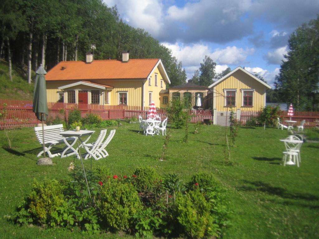 a yellow house with a table and chairs in a yard at Ängbacka in Rejmyre