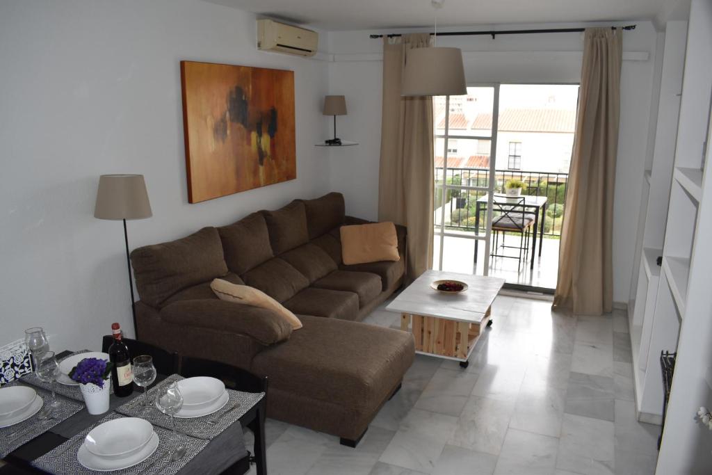 a living room with a couch and a table at Residencial Campomanes in Torremolinos