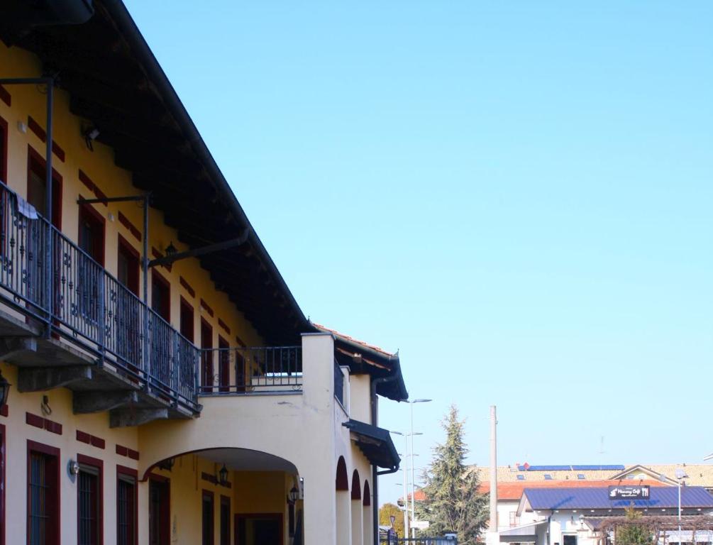 Edificio amarillo y blanco con balcón en Albergo Vecchio Pavone, en Borgaro Torinese