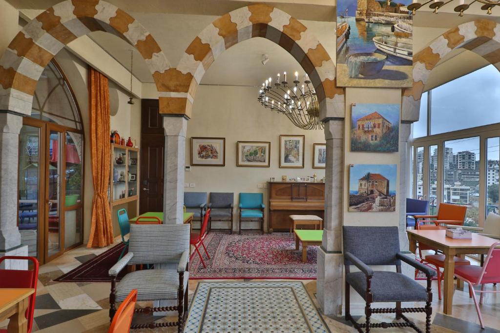 a lobby with arches and tables and chairs at Damask Rose, Lebanese Guest House in Jounieh