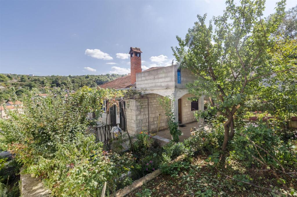 an old house with a chimney and trees at House Fanita in Splitska