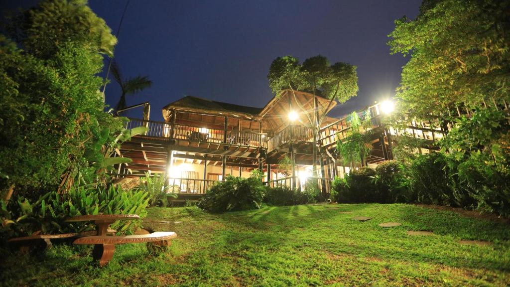 een groot houten gebouw met een tuin in de nacht bij Ndiza Lodge and Cabanas in St Lucia