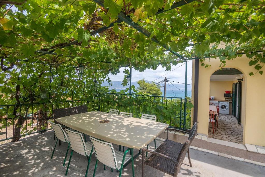 a table and chairs on the balcony of a house at Apartments Rose in Trogir