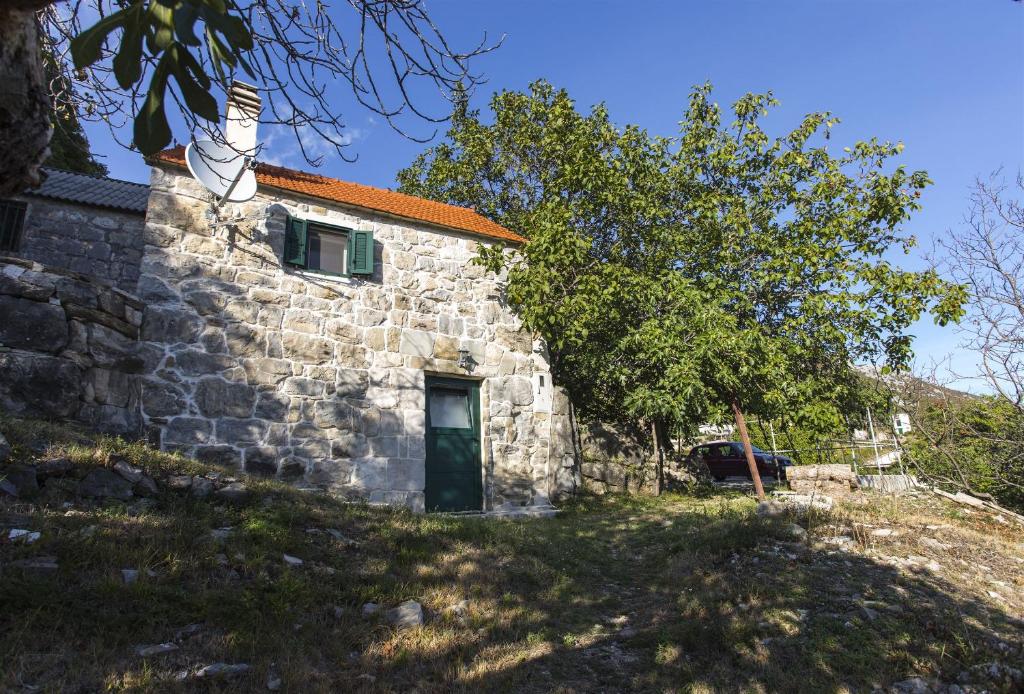 een oud stenen huis met een rood dak bij House Gordana in Gata