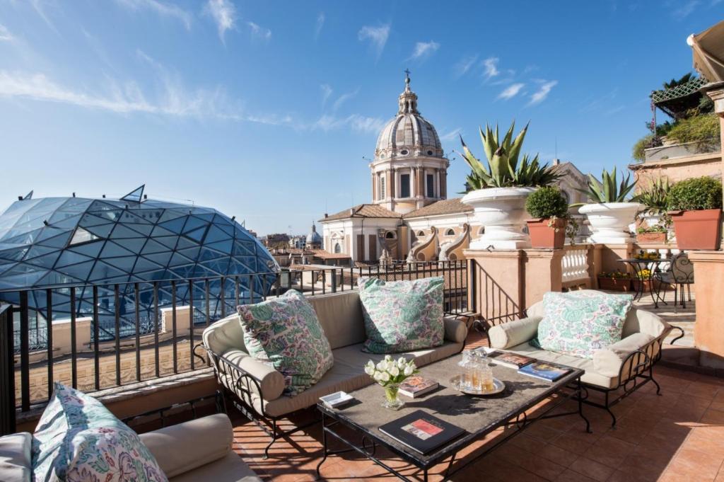 a patio with couches and a table on a roof at Grand Hotel Plaza in Rome