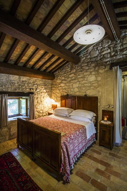 a bedroom with a bed and a stone wall at AGRITURISMO Case Catalano in Abbateggio
