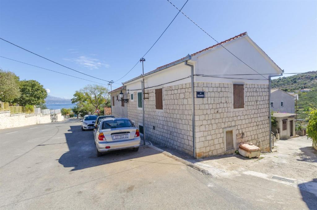 a white car parked next to a brick building at Apartments Anita in Slatine