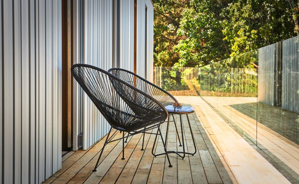 twee zwarte stoelen op een houten terras bij Numad Studios in San Sebastian