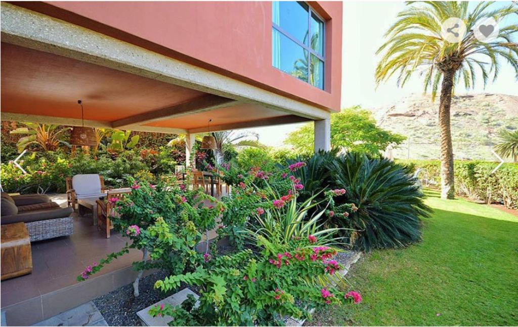 una casa con un patio con flores y plantas en Tabaibas1 @ Salobre Golf, en Salobre