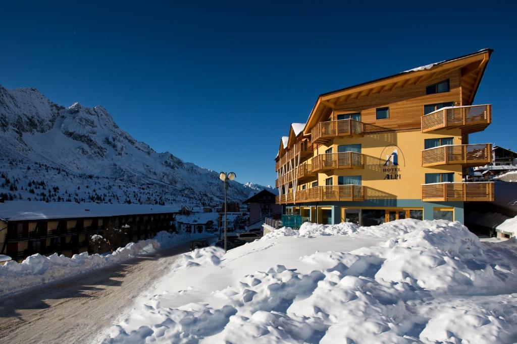 un edificio con un mucchio di neve davanti di Hotel Delle Alpi a Passo del Tonale