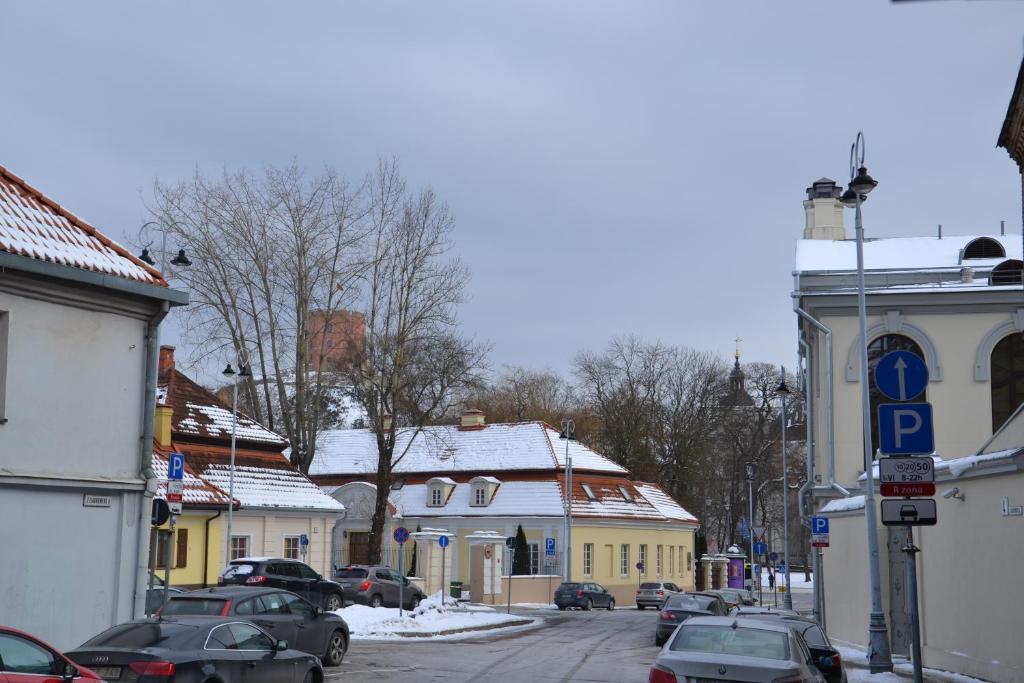 una strada cittadina con auto parcheggiate nella neve di Danarent Tilto a Vilnius