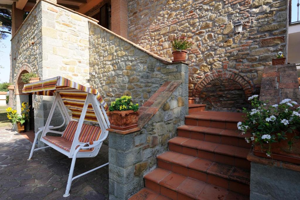 a chair sitting on the porch of a stone building at Boschetto del Lago in Castiglione del Lago