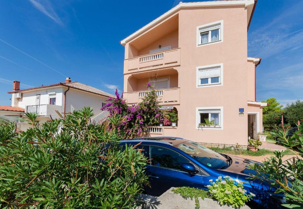 een huis met een auto ervoor geparkeerd bij Apartments Jasmin in Barbat na Rabu