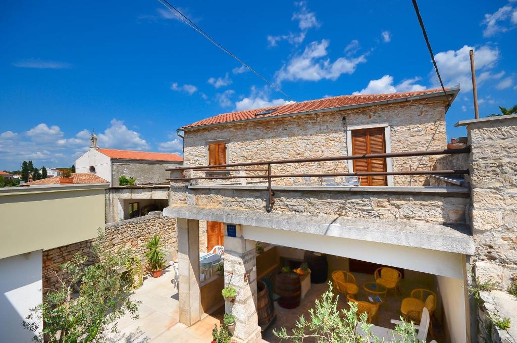 an external view of a stone house with a balcony at House Marija in Fažana