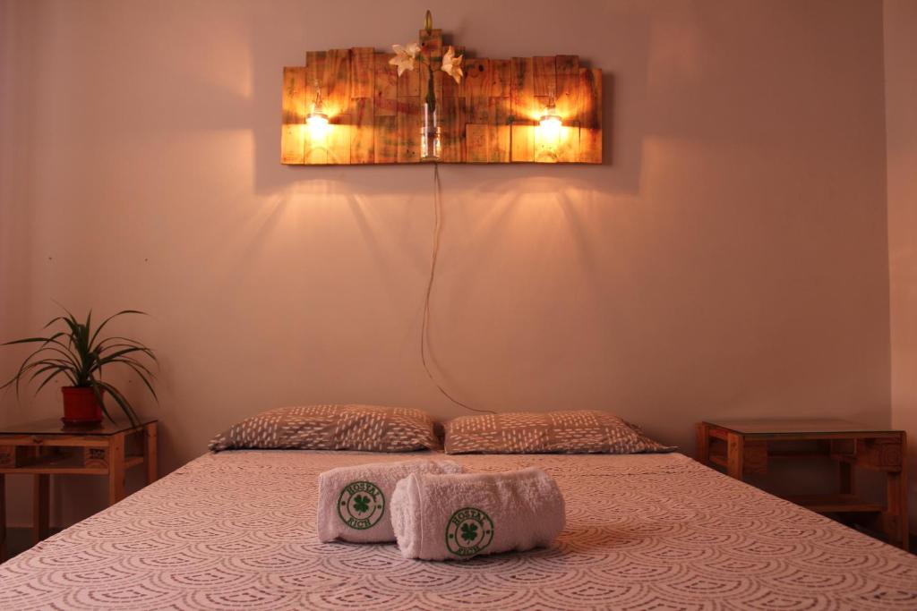 a bedroom with a bed with two towels on it at Hostal Rich in Medellín