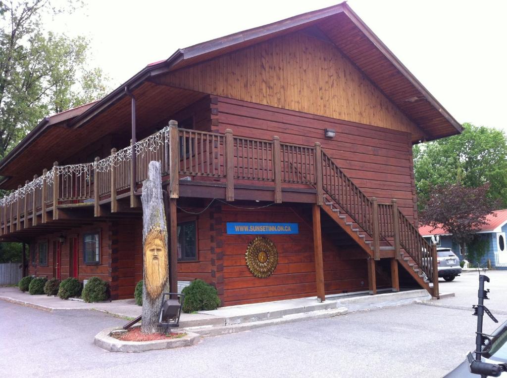 un edificio de madera con una terraza en su lateral en Sunset Inn en North Bay