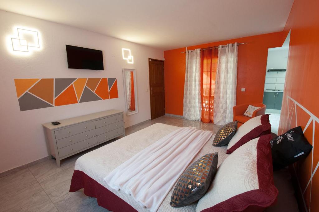 a bedroom with a large bed and a television at Les Gites du Bonheur in Deshaies