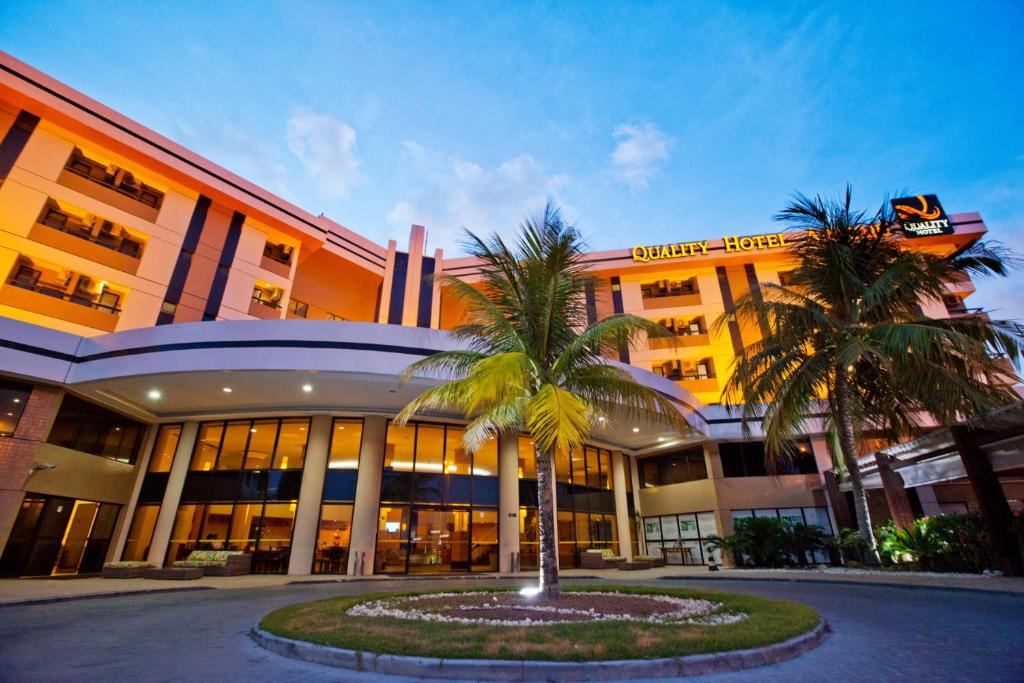 um edifício com duas palmeiras em frente em Quality Hotel Aracaju em Aracaju