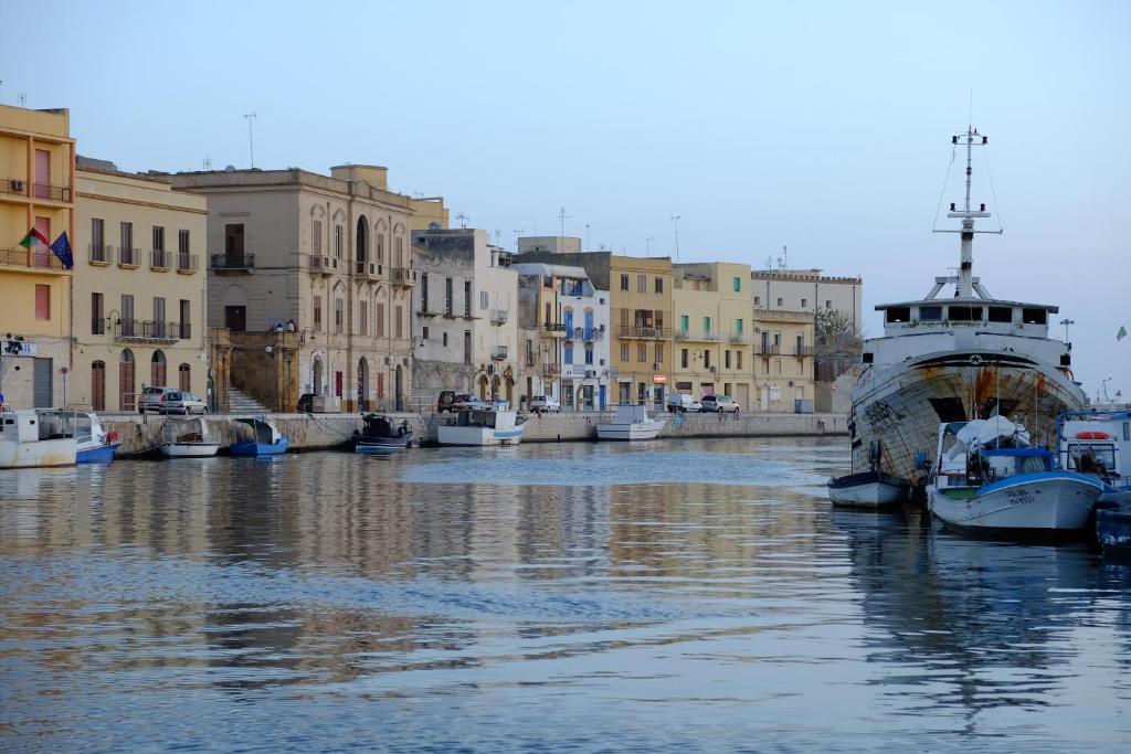 un grupo de barcos atracados en un canal con edificios en Cortile San Giovanni, en Mazara del Vallo