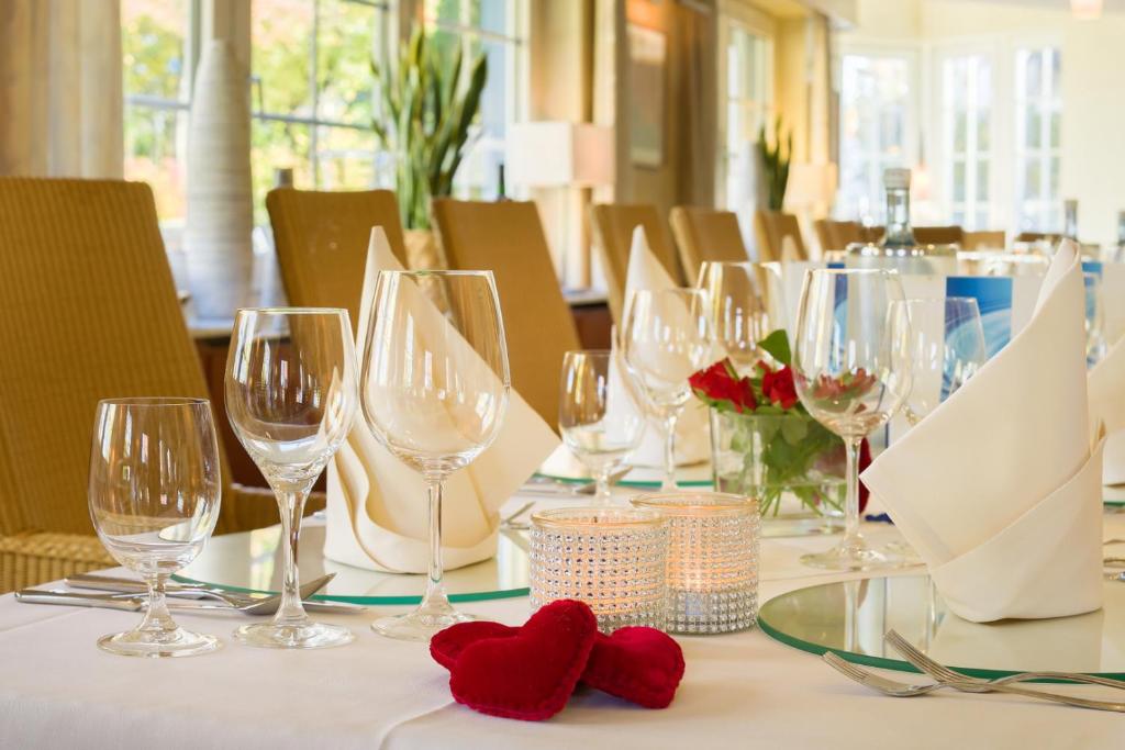 a table with wine glasses and red hearts on it at Hotel Schewe in Löhne