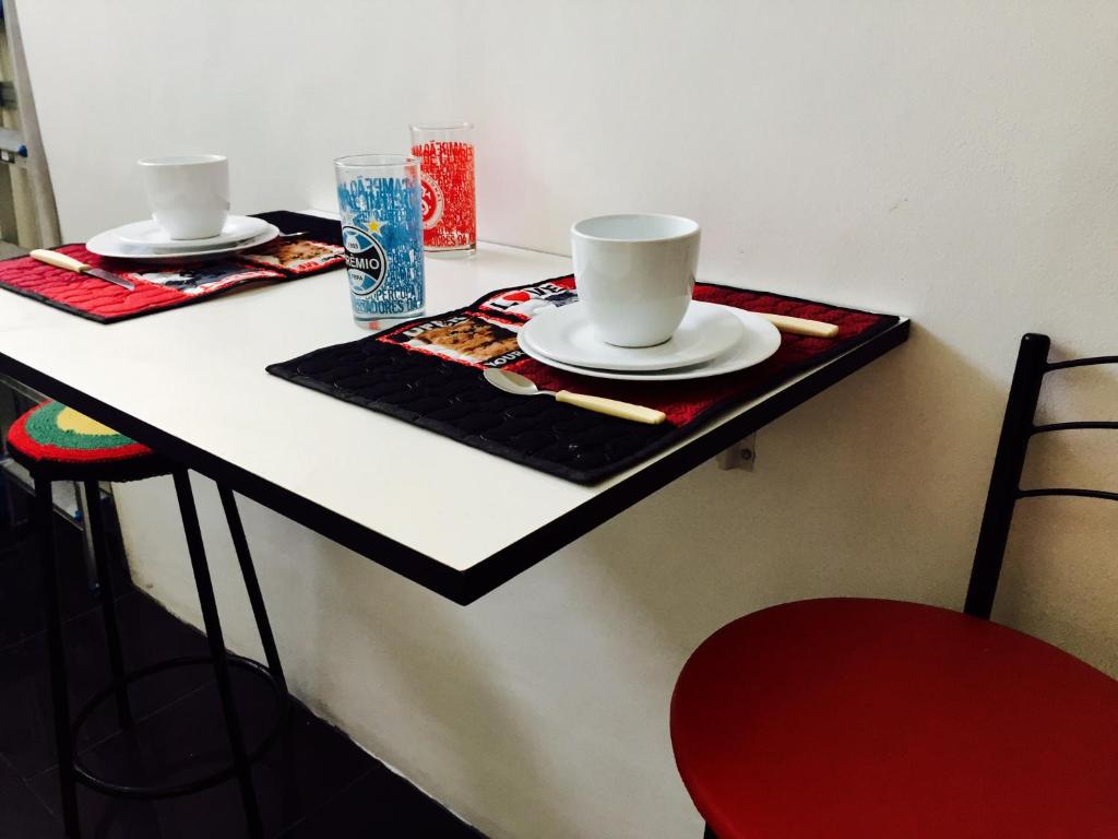 una mesa con dos platos y tazas encima en Casa da Brigite, en Porto Alegre