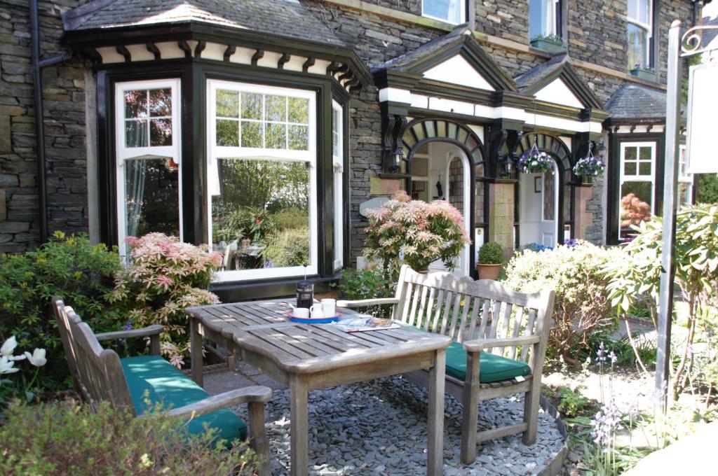 a patio with a table and chairs in front of a house at Haisthorpe Guest House in Windermere