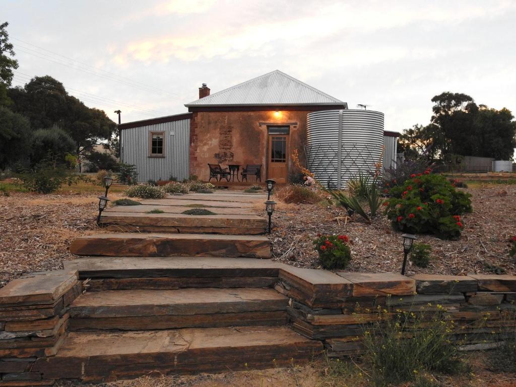 a house with a stone walkway leading to a building at Cooks Cottage in McLaren Vale