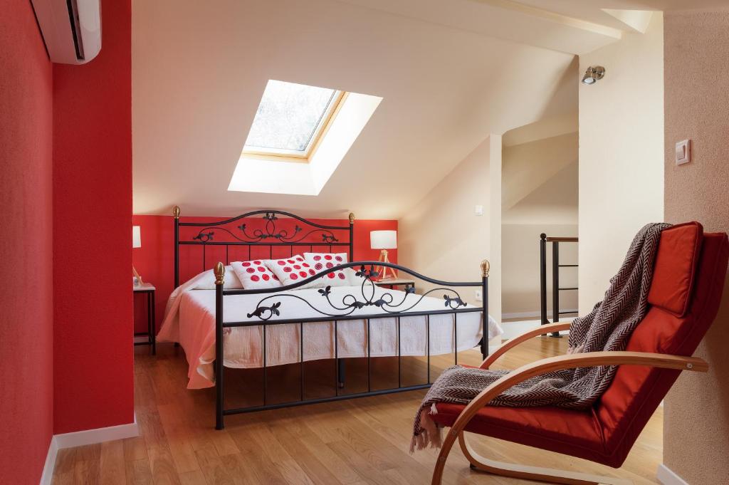 Schlafzimmer mit einem roten Bett und einem Dachfenster in der Unterkunft House Pasalich in Tučepi