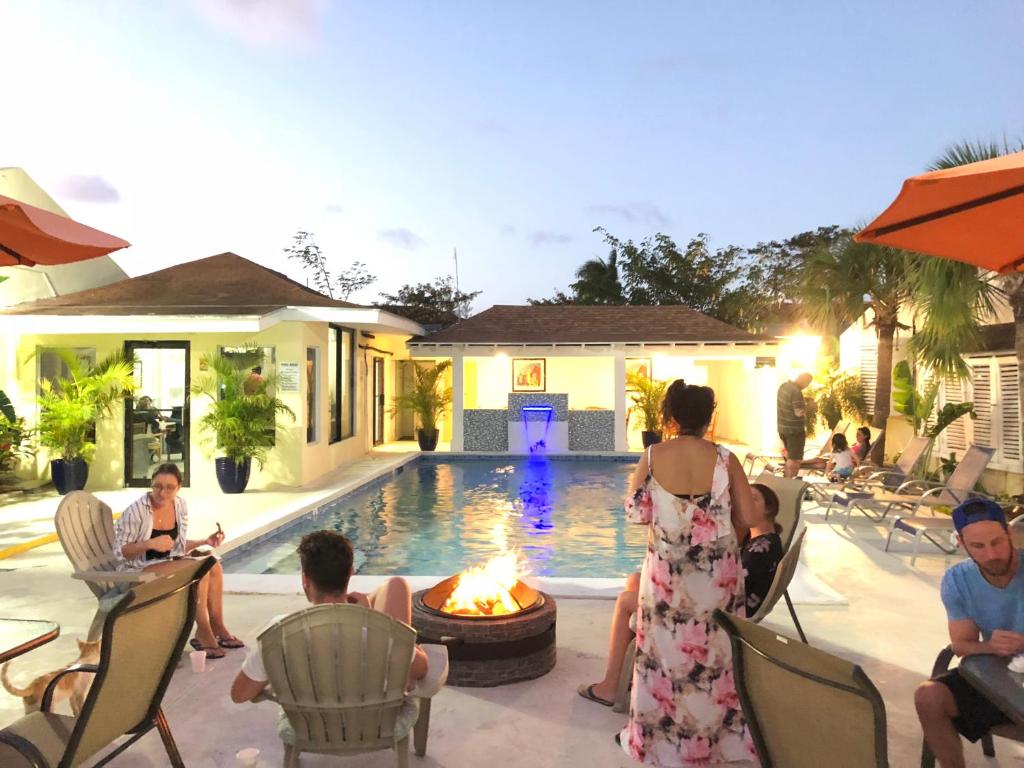 a group of people sitting around a fire pit by a pool at Colony Club Inn & Suites in Nassau