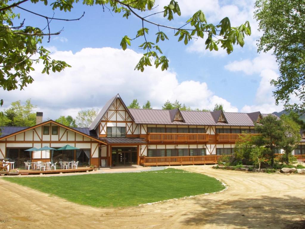 a large house with a gambrel roof at Iwane Sanso in Kawakami