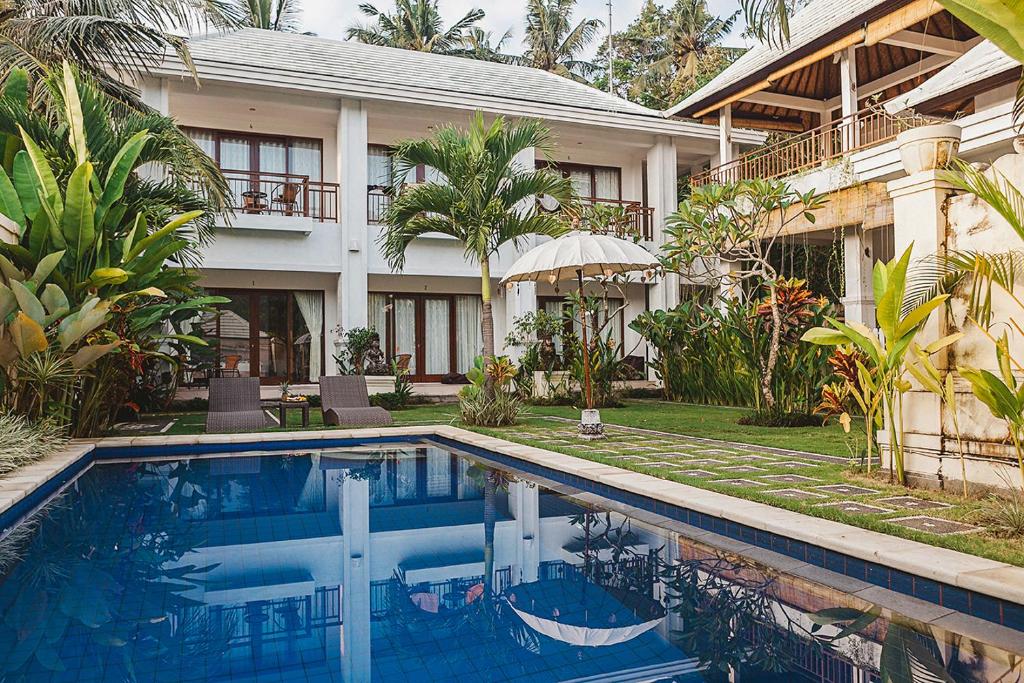 a house with a swimming pool in front of a house at Gerke House in Ubud
