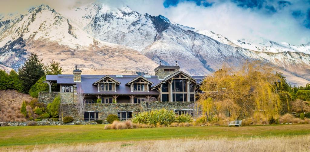
a large building with a mountain range in front of it at Blanket Bay in Glenorchy
