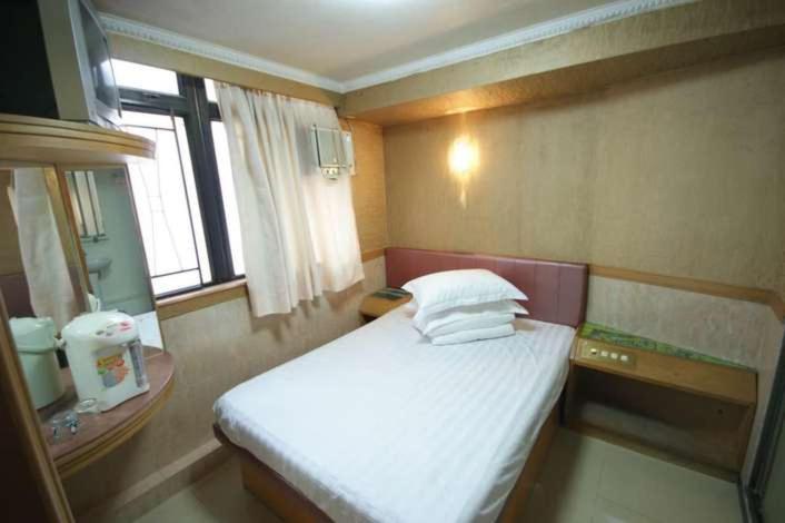Habitación pequeña con cama y ventana en Astronaut's Hotel en Hong Kong