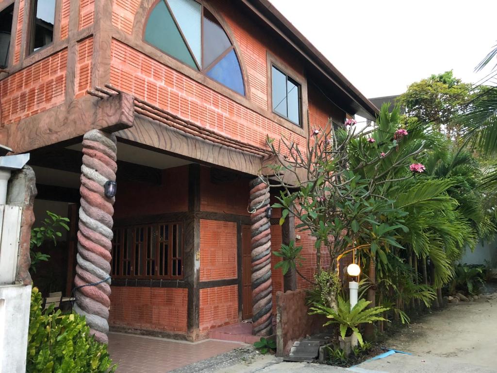 una casa de ladrillo rojo con una gran puerta de madera en Villa Kamala Beach, en Kamala Beach