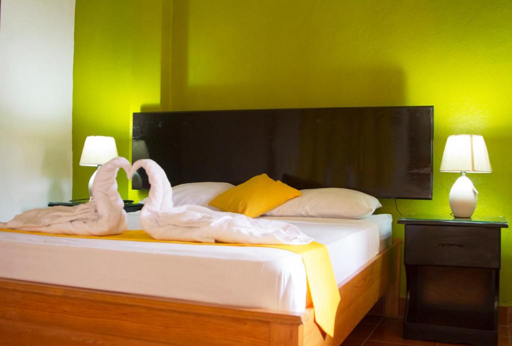 two swans sitting on a bed in a bedroom at Casa Brenes in Matagalpa