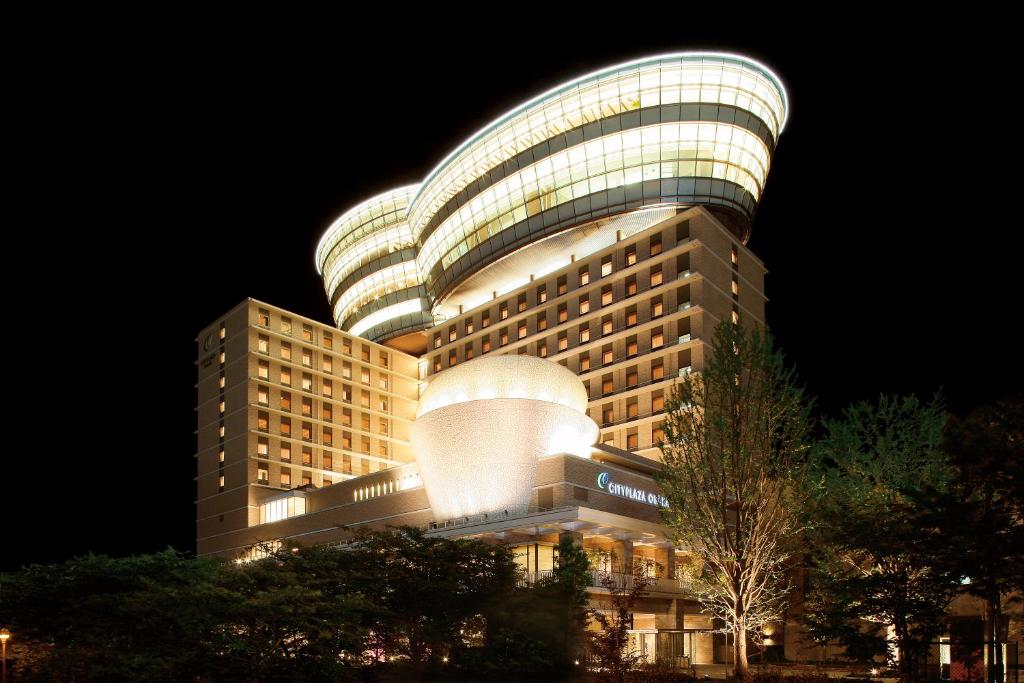 a large building with a lit up facade at night at City Plaza Osaka in Osaka