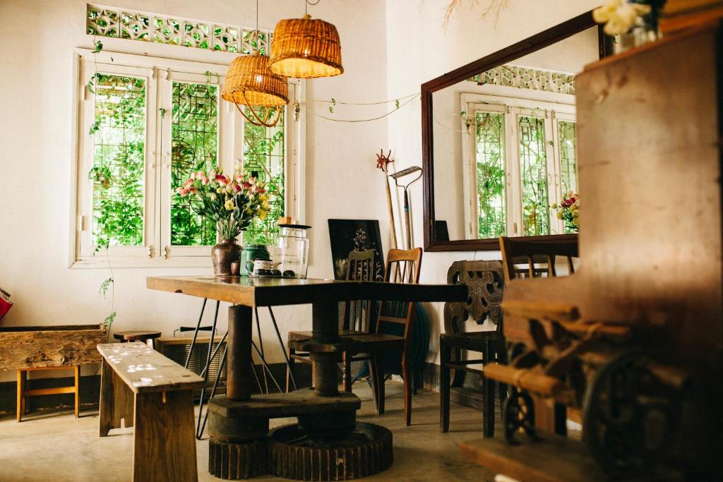 ein Raum mit Tisch und Stühlen und Fenstern in der Unterkunft Tre House Dalat in Da Lat