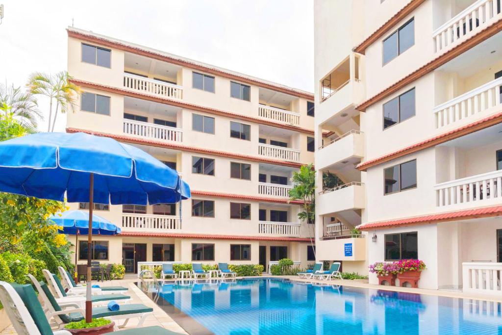 a hotel with a swimming pool and an umbrella at The Residence Garden in Pattaya South