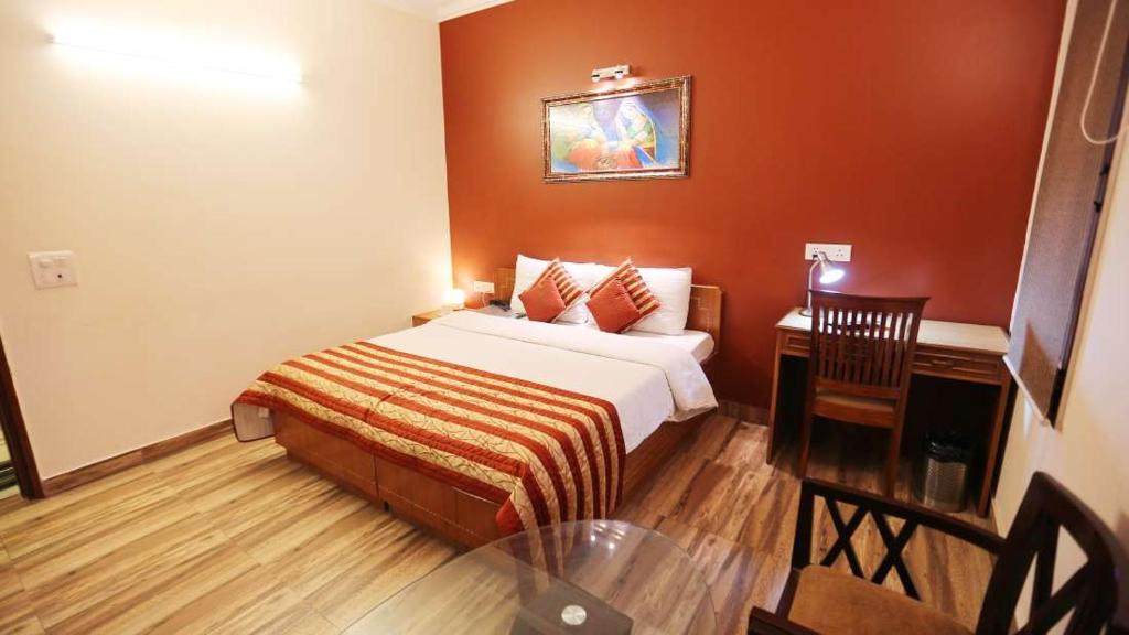 una camera d'albergo con letto e tavolo di Pals Inn a Nuova Delhi