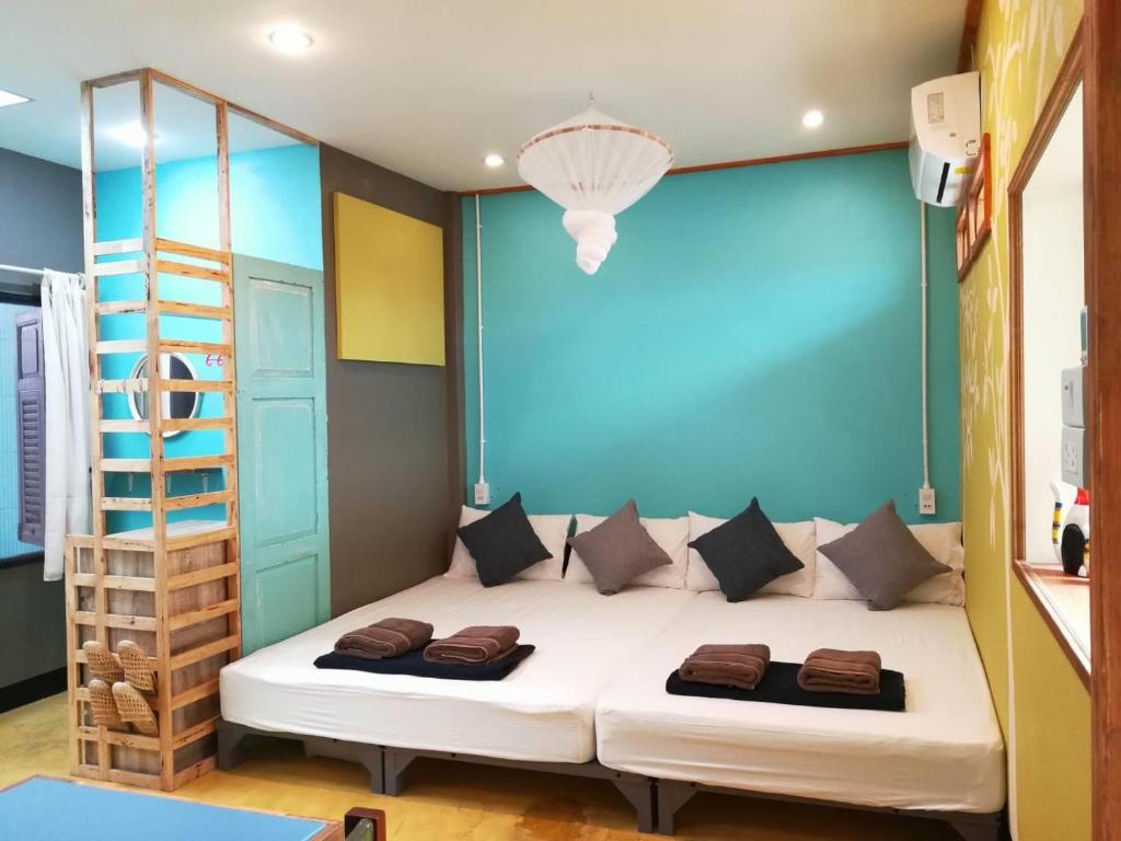 a bedroom with a bed with a blue wall at 60 Blue House in Chiang Mai