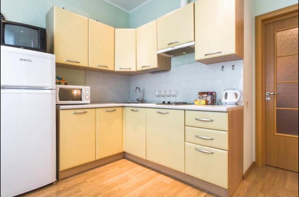 モスクワにあるNa Kirovogradskoy Apartmentのキッチン(白いキャビネット、白い冷蔵庫付)
