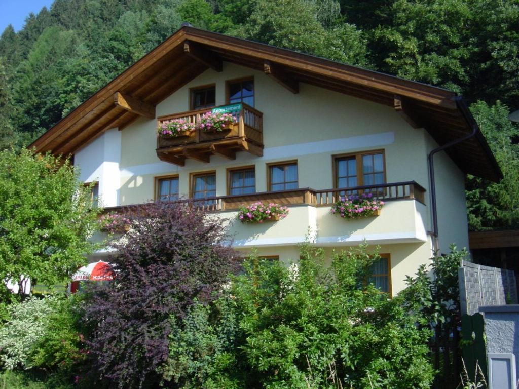 a house with a balcony and flowers on it at Appartement Bruckberg in Zell am See