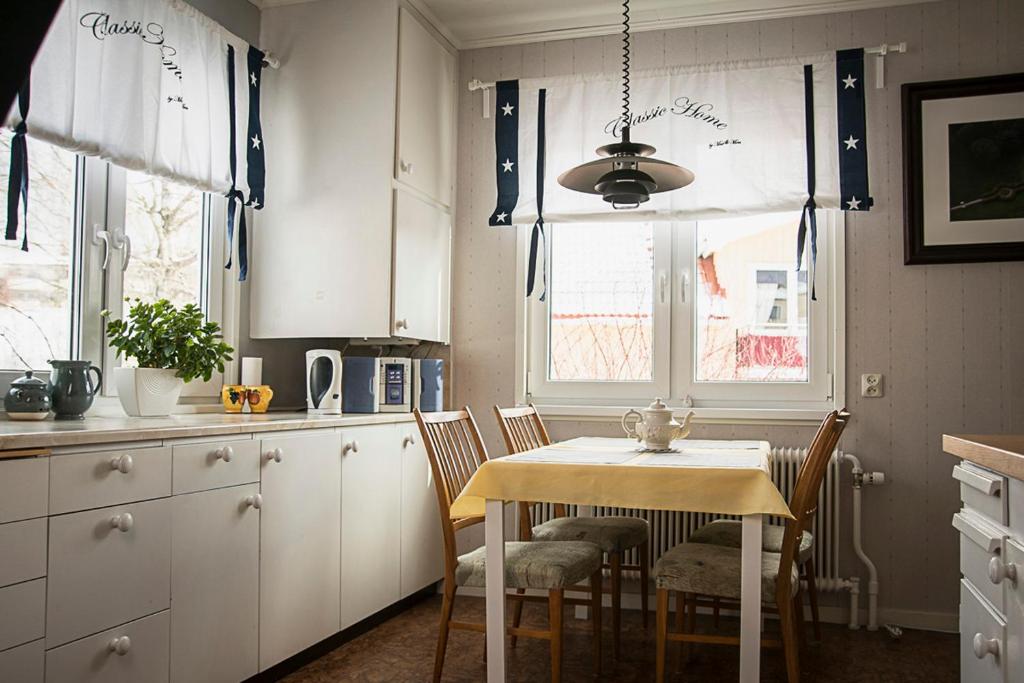 a kitchen with a table and chairs in a kitchen at Photoeverhome in Bengtsfors