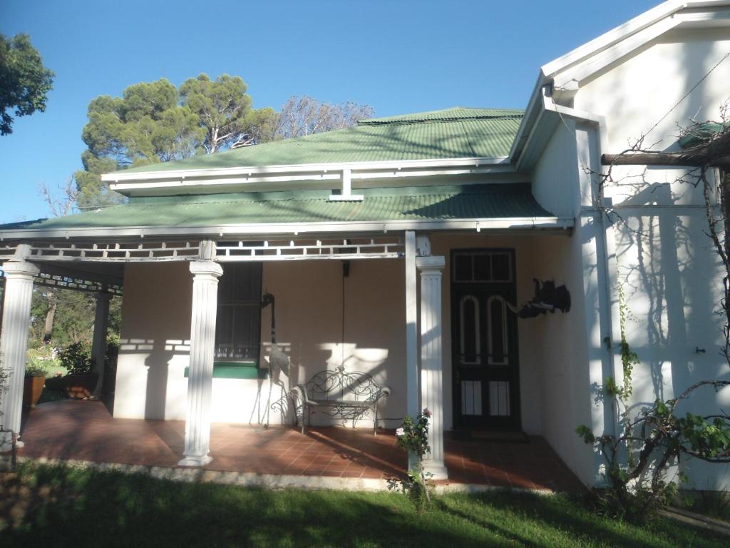 a white house with a pergola at Smithfield House in Smithfield