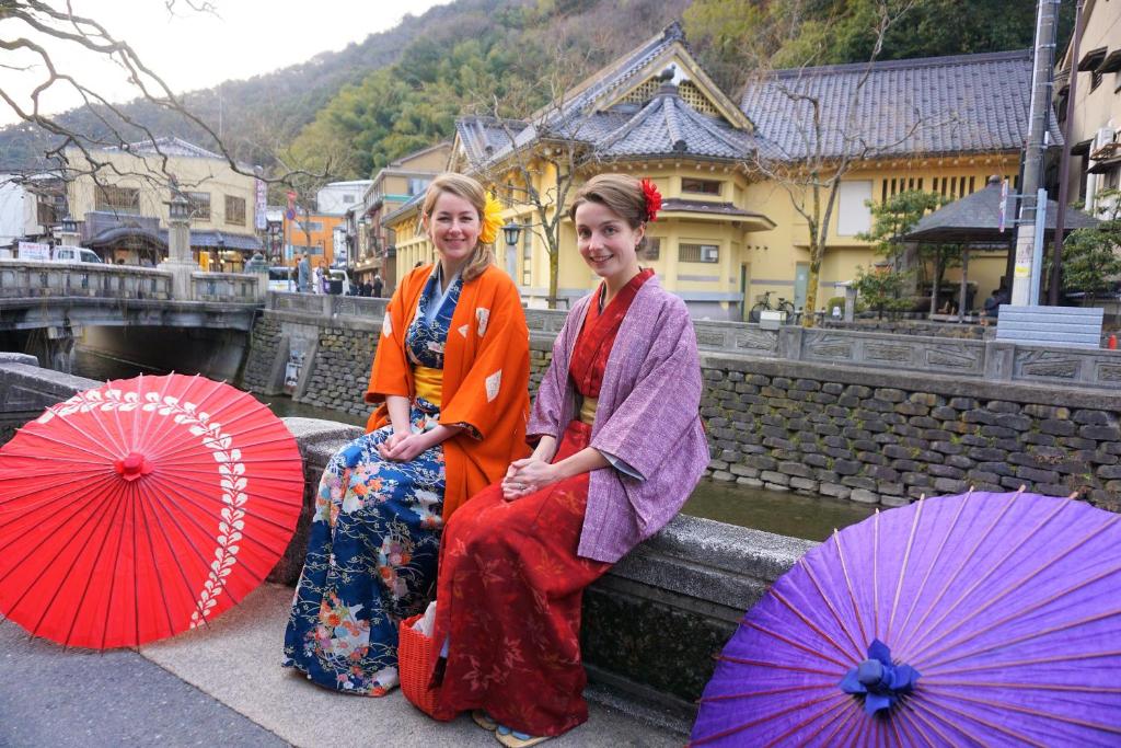 deux femmes assises sur un rebord avec des parapluies dans l'établissement Morizuya, à Toyooka 291 autres photos